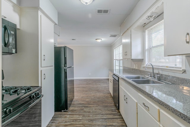 kitchen featuring black appliances, a sink, dark wood finished floors, baseboards, and light countertops
