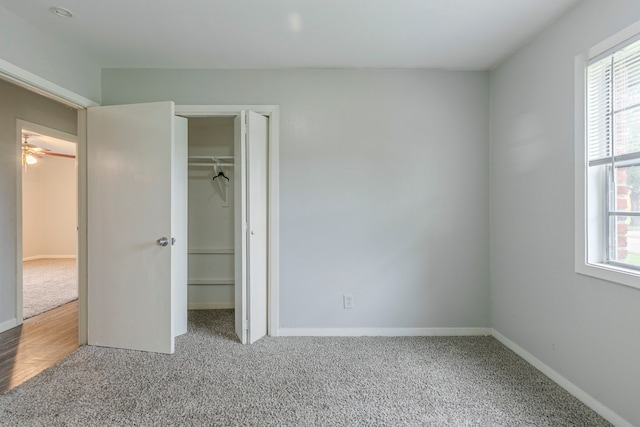 unfurnished bedroom featuring carpet floors, baseboards, a closet, and a walk in closet