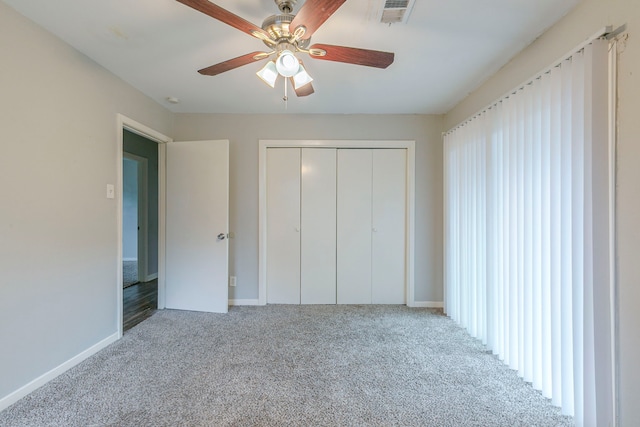 unfurnished bedroom featuring carpet floors, a closet, baseboards, and ceiling fan