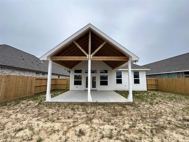 back of property with a fenced backyard, a patio area, and french doors