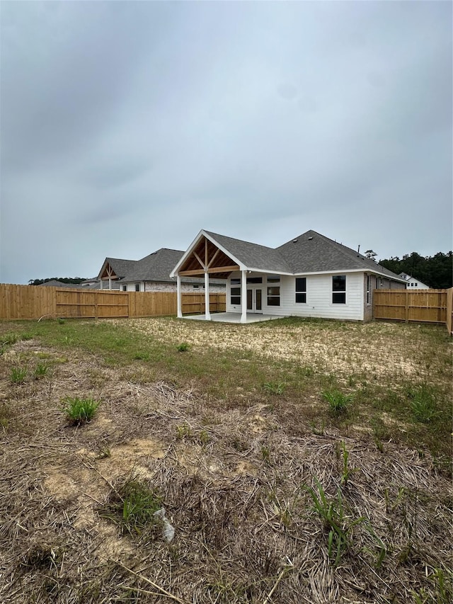 rear view of property with a patio and a fenced backyard