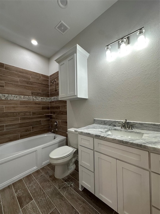 full bathroom with toilet,  shower combination, wood tiled floors, vanity, and recessed lighting