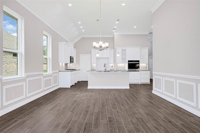 310 Little Spring Ct, Anahuac, TX 77514 - kitchen with oven, a chandelier, an island with sink, white cabinetry, and crown molding