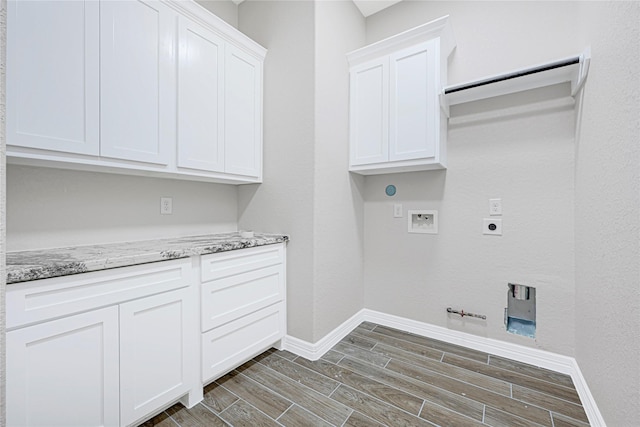 310 Little Spring Ct, Anahuac, TX 77514 - clothes washing area featuring wood finish floors, gas dryer hookup, washer hookup, baseboards, and cabinet space
