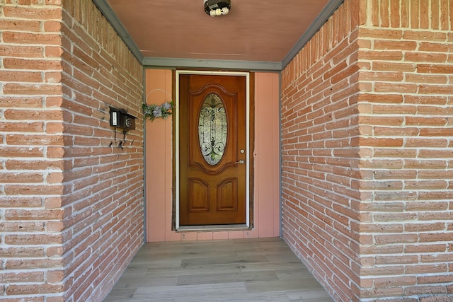 view of exterior entry with brick siding