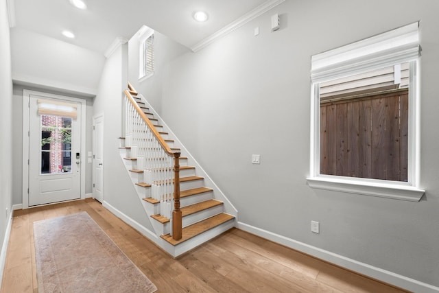foyer entrance featuring baseboards, wood-type flooring, stairs, recessed lighting, and ornamental molding