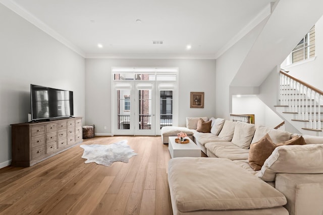 living room featuring light wood-type flooring, baseboards, ornamental molding, stairway, and recessed lighting