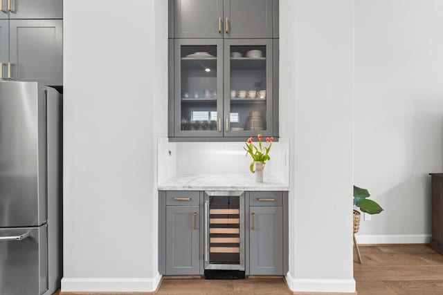 118 Reinerman St, Houston, TX 77007 - bar with freestanding refrigerator, wine cooler, light wood-type flooring, and baseboards