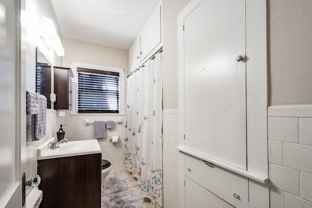 111 S Roosevelt Ave, Cleveland, TX 77327 - full bathroom featuring tile walls, toilet, vanity, a wainscoted wall, and a shower with curtain