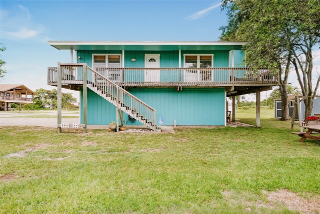 back of property with stairway, a yard, and a deck