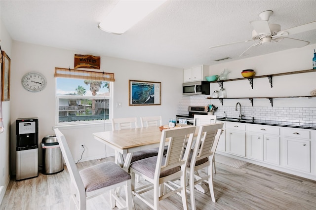 dining room with light wood-type flooring and ceiling fan