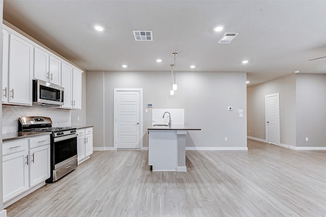 8119 Blue Fish Dr, Cypress, TX 77433 - kitchen with stainless steel appliances, dark countertops, backsplash, light wood-style floors, and recessed lighting