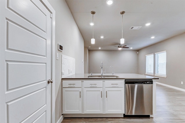 8119 Blue Fish Dr, Cypress, TX 77433 - kitchen featuring dishwasher, a sink, a peninsula, light wood finished floors, and white cabinets