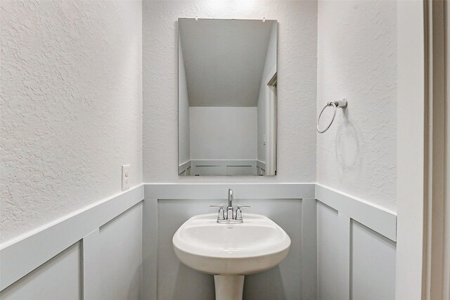 8119 Blue Fish Dr, Cypress, TX 77433 - bathroom with a textured wall, a decorative wall, a wainscoted wall, and a sink