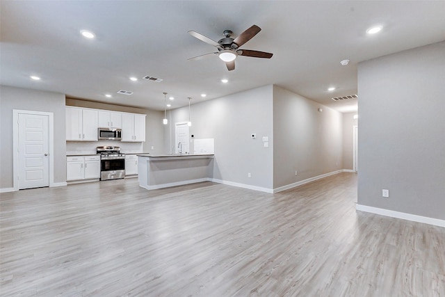 8119 Blue Fish Dr, Cypress, TX 77433 - unfurnished living room featuring ceiling fan, baseboards, recessed lighting, light wood-style flooring, and a sink