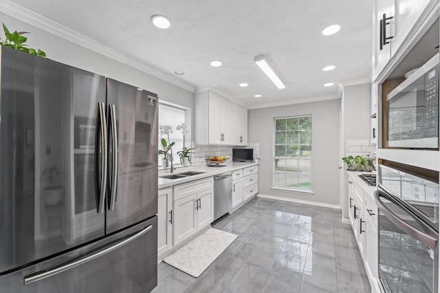 16603 April Hill St, Houston, TX 77095 - kitchen with appliances with stainless steel finishes, ornamental molding, a sink, tasteful backsplash, and light countertops