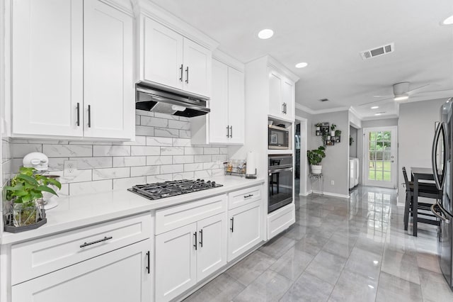 16603 April Hill St, Houston, TX 77095 - kitchen featuring stainless steel appliances, under cabinet range hood, washer / clothes dryer, ornamental molding, and tasteful backsplash