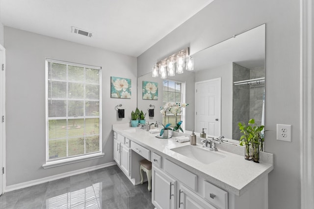 16603 April Hill St, Houston, TX 77095 - bathroom featuring tiled shower, baseboards, and double vanity