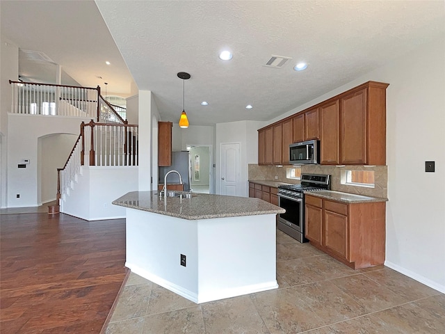 3306 Cactus Heights Ln, Pearland, TX 77581 - kitchen with stainless steel appliances, a sink, brown cabinetry, baseboards, and decorative backsplash