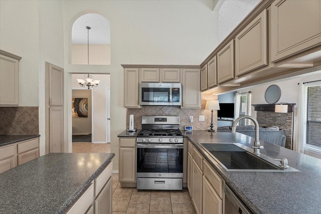 9302 Kirkchapel Ct, Spring, TX 77379 - kitchen featuring stainless steel appliances, a sink, dark countertops, a chandelier, and tasteful backsplash