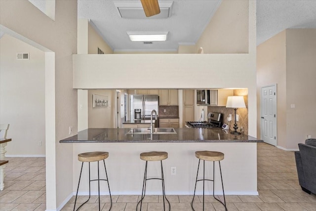 9302 Kirkchapel Ct, Spring, TX 77379 - kitchen with stainless steel appliances, a peninsula, a sink, decorative backsplash, and light tile patterned floors