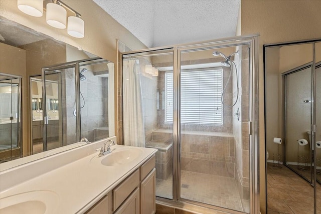9302 Kirkchapel Ct, Spring, TX 77379 - bathroom with a shower stall, tile patterned flooring, double vanity, and a textured ceiling