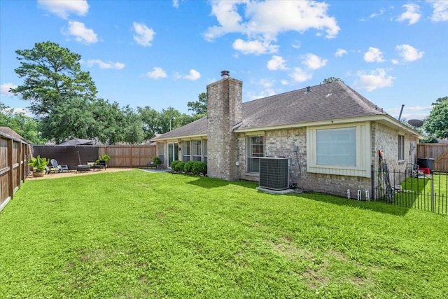 9302 Kirkchapel Ct, Spring, TX 77379 - back of house with central air condition unit, a chimney, a patio area, roof with shingles, and brick siding