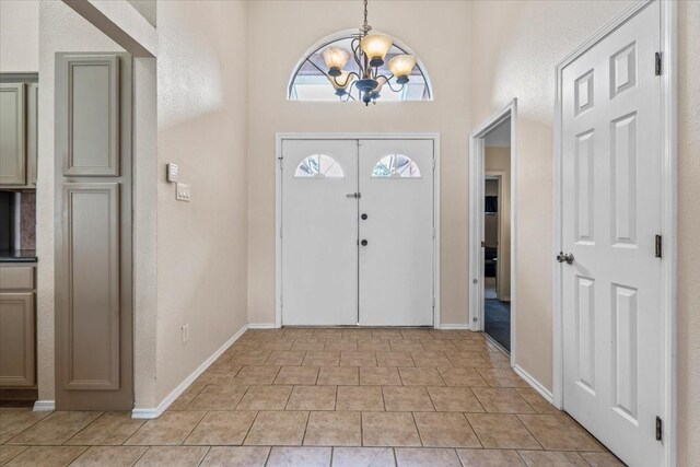 9302 Kirkchapel Ct, Spring, TX 77379 - foyer entrance with a chandelier, light tile patterned flooring, and baseboards