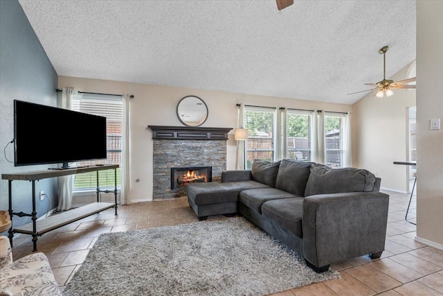 9302 Kirkchapel Ct, Spring, TX 77379 - living room featuring ceiling fan, a textured ceiling, plenty of natural light, a stone fireplace, and lofted ceiling