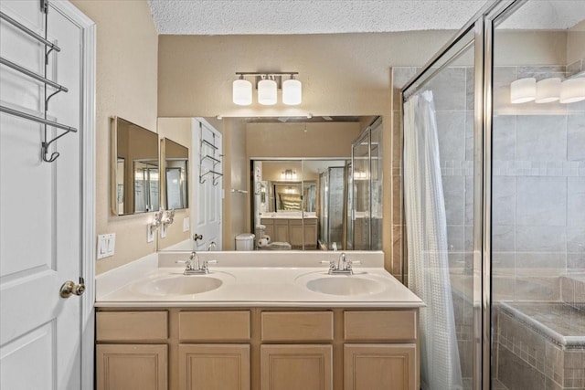 9302 Kirkchapel Ct, Spring, TX 77379 - bathroom featuring a shower stall, double vanity, a textured ceiling, and toilet