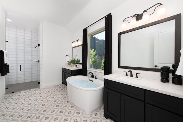 full bathroom featuring a shower stall, a soaking tub, two vanities, and baseboards