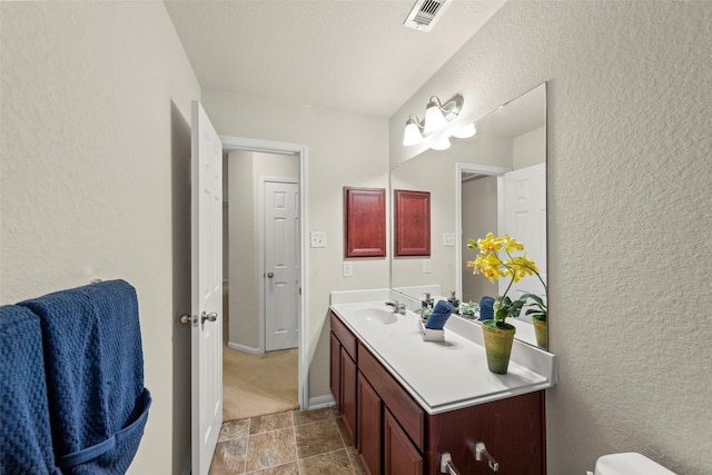 15010 Calico Heights Ln, Cypress, TX 77433 - half bath featuring a textured wall, vanity, stone finish flooring, toilet, and baseboards