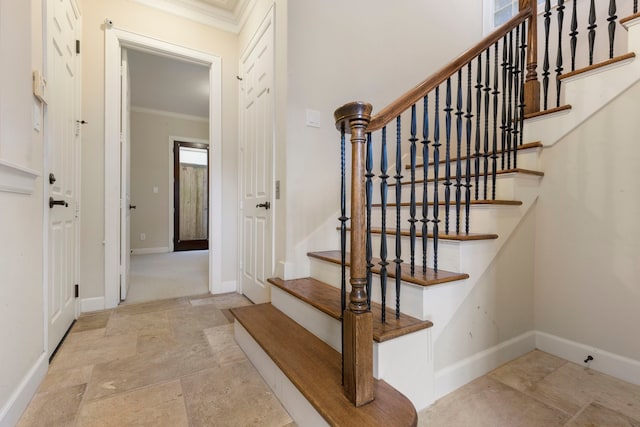 stairs with stone finish flooring, crown molding, and baseboards