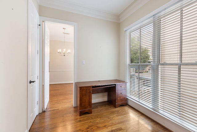 doorway with crown molding, a chandelier, wood finished floors, and baseboards