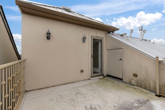 rear view of house featuring a patio area and stucco siding