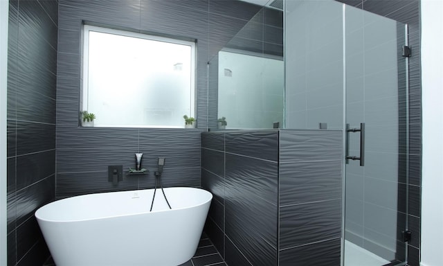 1224 Johnston St, Houston, TX 77022 - full bath featuring tile walls, plenty of natural light, a shower stall, and a soaking tub