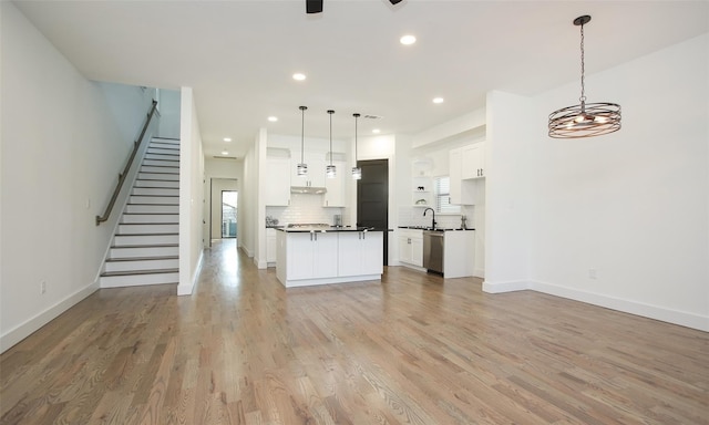 1224 Johnston St, Houston, TX 77022 - kitchen featuring open floor plan, dishwasher, a sink, white cabinets, and light wood finished floors