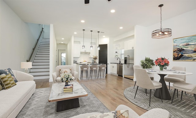 1224 Johnston St, Houston, TX 77022 - living area featuring stairs, light wood finished floors, recessed lighting, a chandelier, and healthy amount of natural light