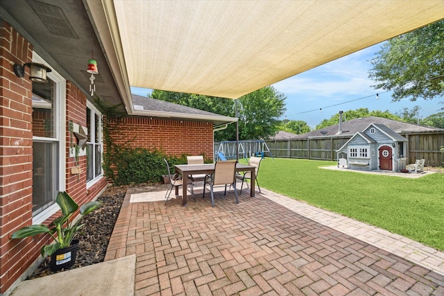 view of patio with an outbuilding, outdoor dining space, and a shed