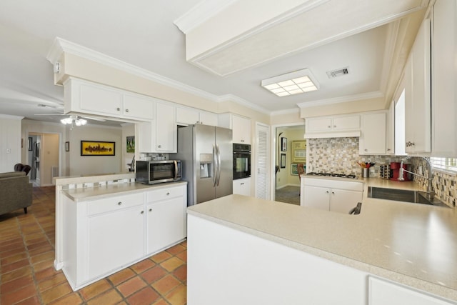 1410 Saxony Ln, Nassau Bay, TX 77058 - kitchen with a peninsula, a sink, appliances with stainless steel finishes, crown molding, and tasteful backsplash