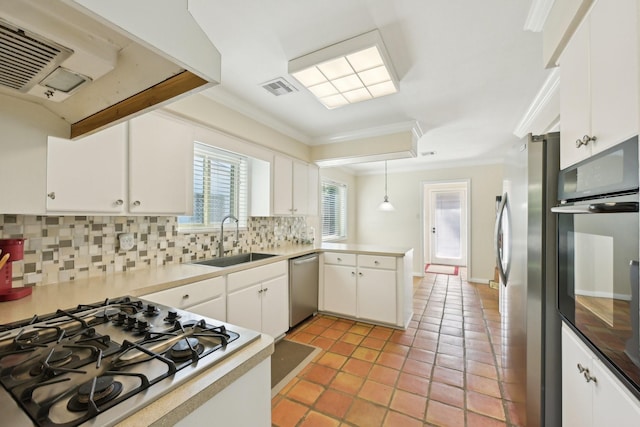 1410 Saxony Ln, Nassau Bay, TX 77058 - kitchen with a sink, appliances with stainless steel finishes, crown molding, a peninsula, and tasteful backsplash