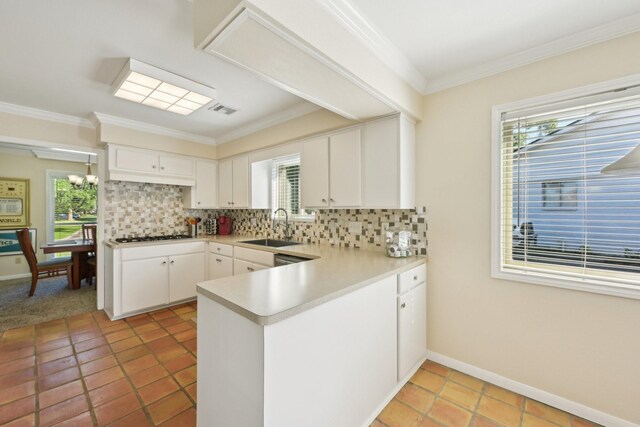 1410 Saxony Ln, Nassau Bay, TX 77058 - kitchen featuring a sink, a peninsula, tasteful backsplash, crown molding, and light countertops