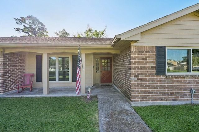 1410 Saxony Ln, Nassau Bay, TX 77058 - doorway to property featuring brick siding, a yard, and a shingled roof