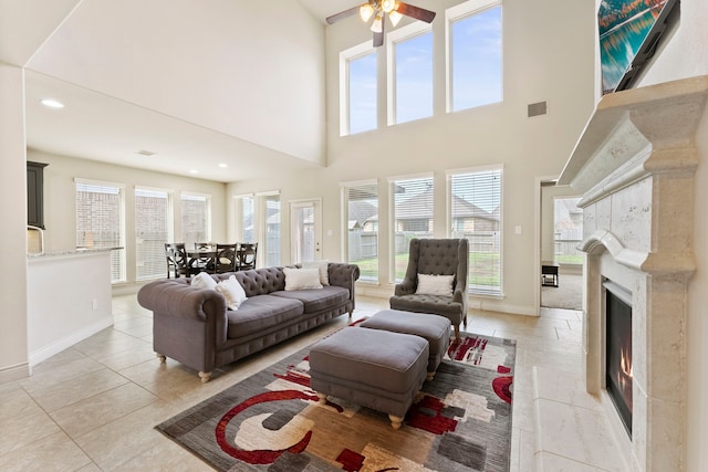27935 Chiapas Dr, Spring, TX 77386 - living room with baseboards, a fireplace, a ceiling fan, a towering ceiling, and light tile patterned flooring