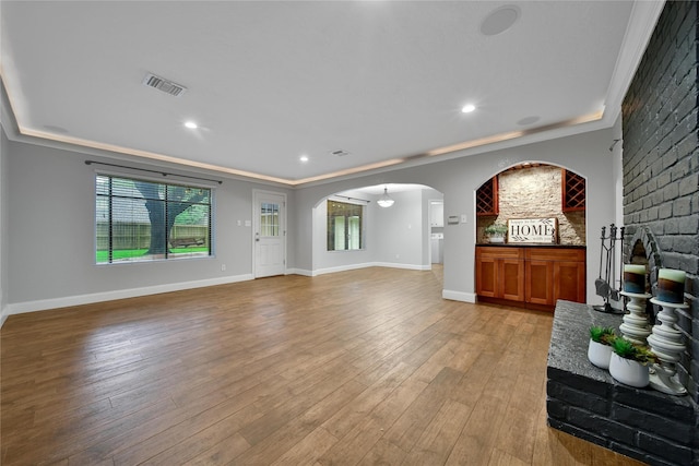 12443 Honeywood Trl, Houston, TX 77077 - unfurnished living room featuring arched walkways, crown molding, light wood-style flooring, baseboards, and recessed lighting