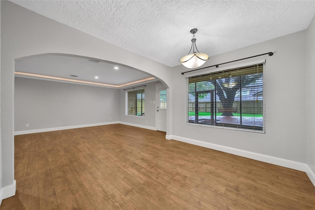 12443 Honeywood Trl, Houston, TX 77077 - spare room with arched walkways, wood finished floors, baseboards, a textured ceiling, and recessed lighting