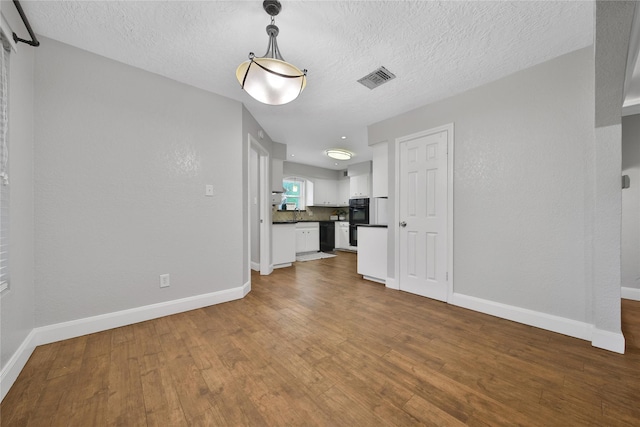 12443 Honeywood Trl, Houston, TX 77077 - unfurnished living room featuring baseboards, dark wood-style floors, and a textured ceiling