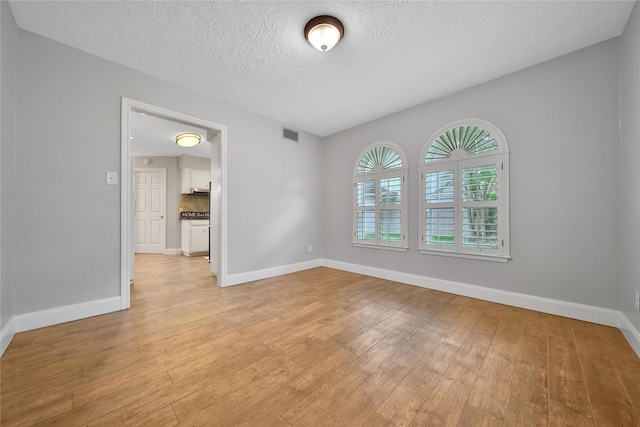 12443 Honeywood Trl, Houston, TX 77077 - empty room featuring baseboards, light wood-style flooring, and a textured ceiling