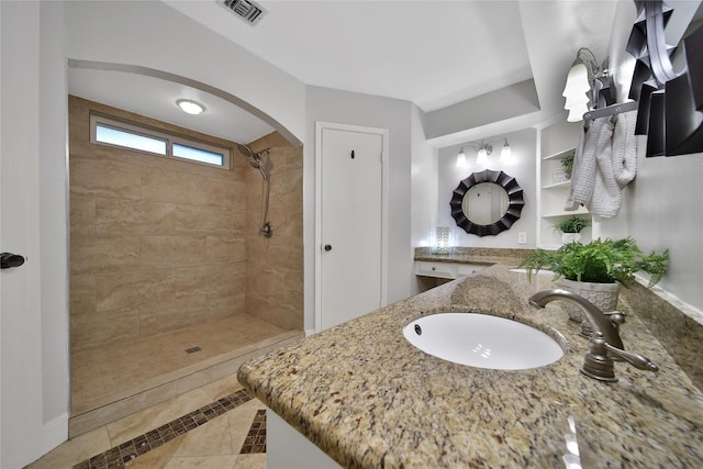 12443 Honeywood Trl, Houston, TX 77077 - full bath with a tile shower, double vanity, tile patterned floors, and inlaid floor details