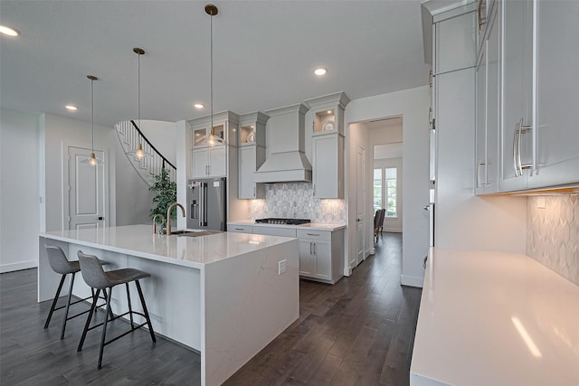 29851 Aaron River Trl, Fulshear, TX 77441 - kitchen featuring gas stovetop, custom exhaust hood, dark wood finished floors, high quality fridge, and tasteful backsplash